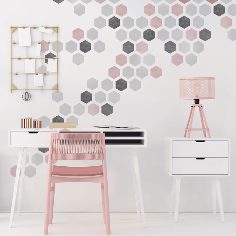 A white wall stencilled with a hexagons design in pale pink, grey and charcoal.