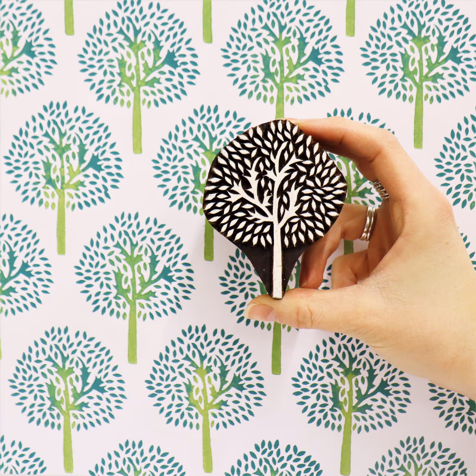 Indian blocked wall depicting a tree design in green and blue on a white wall.