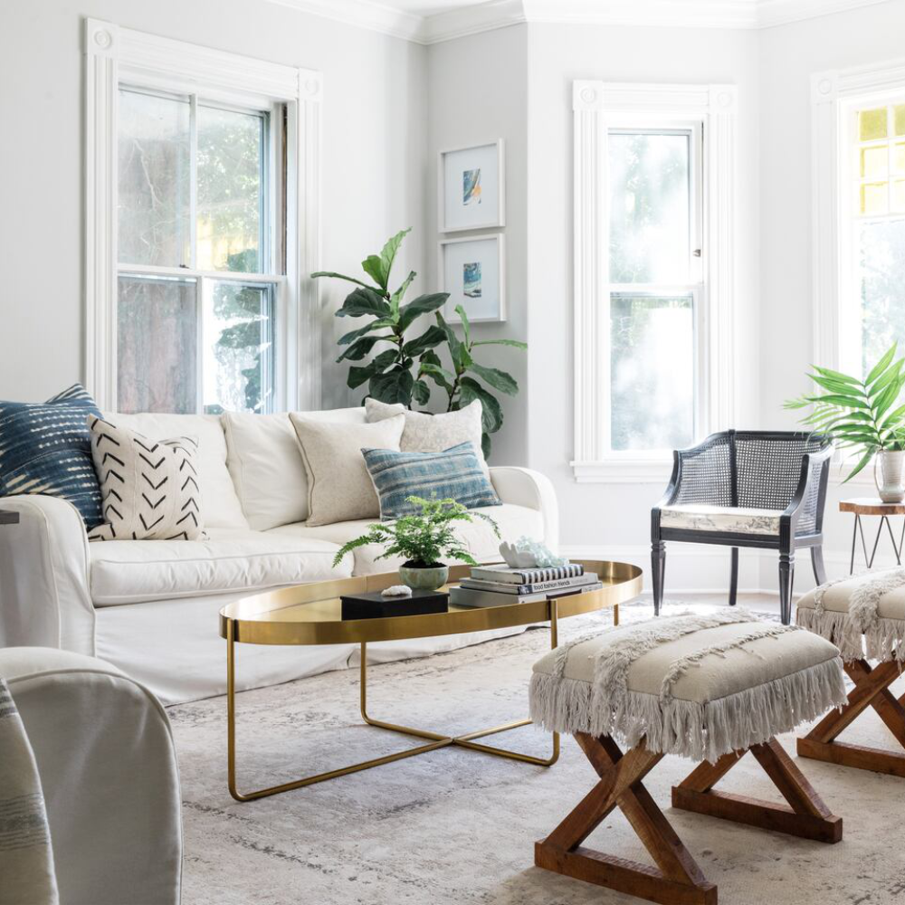 A soothing coastal themed living room primarily using white with blue accents and natural wood furniture.