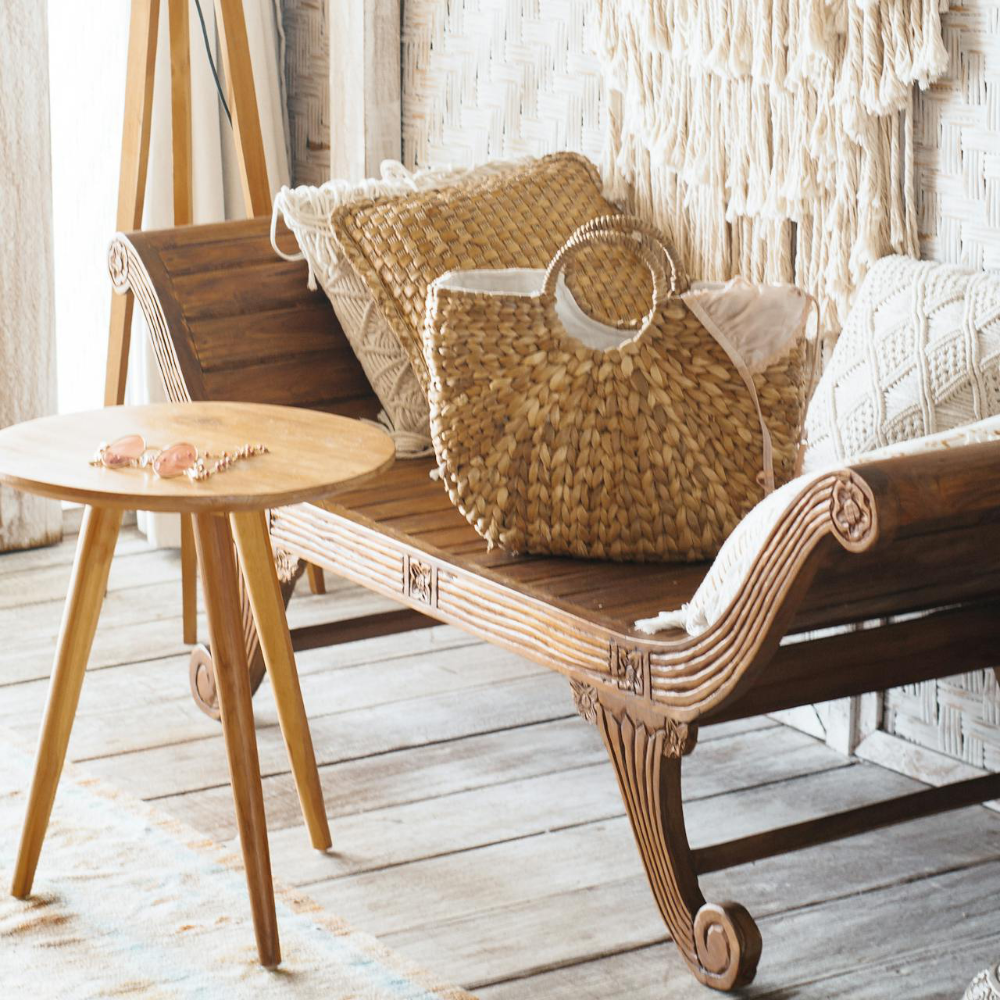 An old teak love seat with basketwares and a macrame wall hanging.