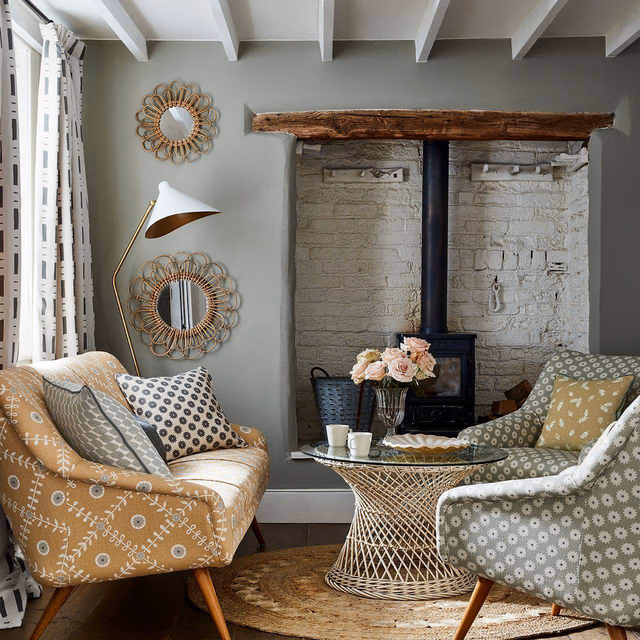 A modern country living room with a linen upholstered sofa and armchair and a bamboo centre tab le.
