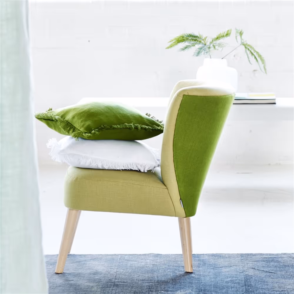 A modern side chair upholstered in dark and light green linen fabric.